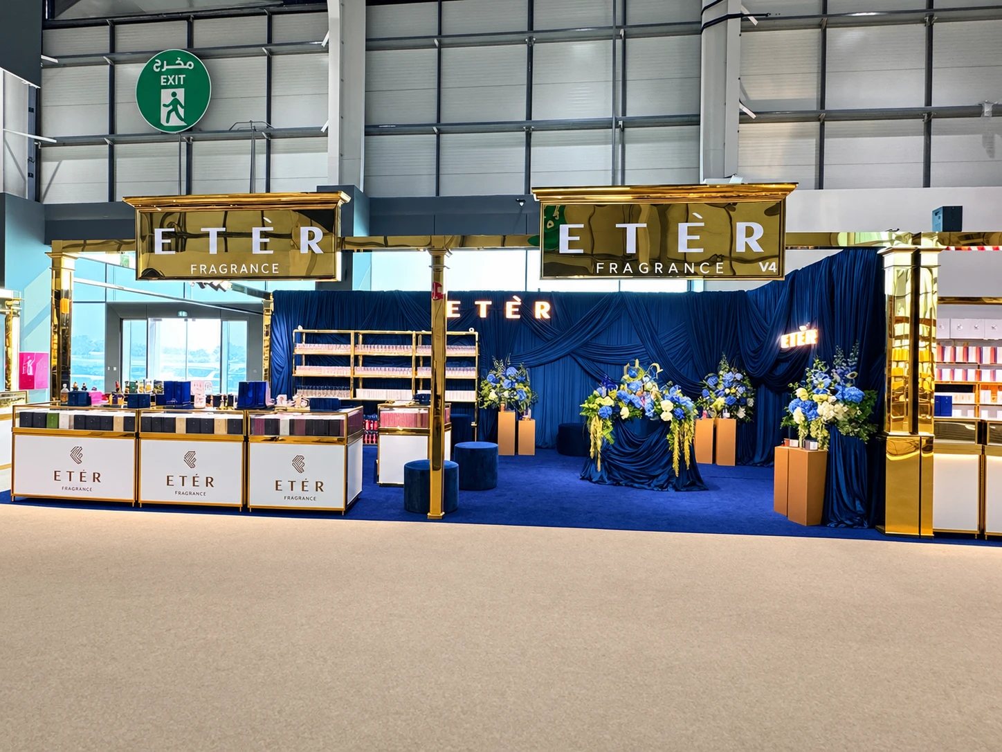 Etèr Fragrance exhibition stand at Teeb Al Hazm, ADNEC Abu Dhabi, with gold fascia signage, navy draping, navy carpet and branded display counters