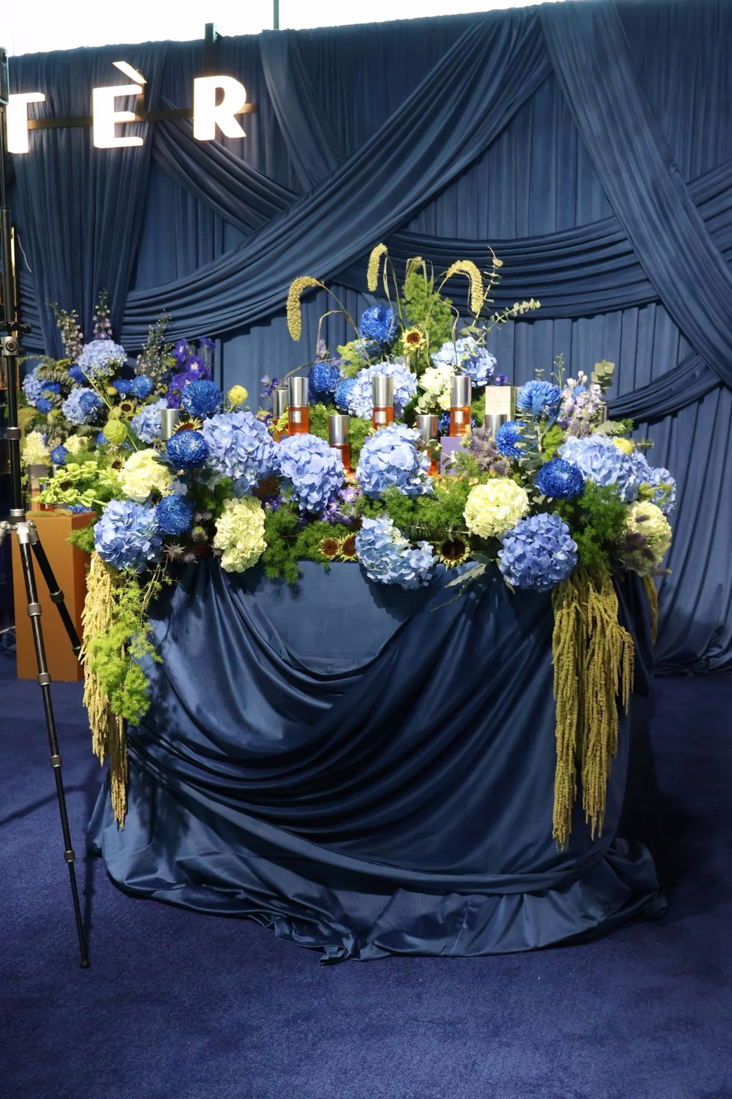 Navy draped centre table with Etèr Fragrance bottles, blue and white hydrangeas and illuminated Etèr letters at ADNEC Abu Dhabi